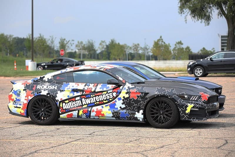 Profile black Mustang with Autism Awareness wrap around it 