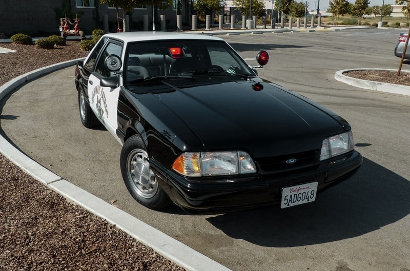 Front of a black highway patrol Mustang LX in parking lot