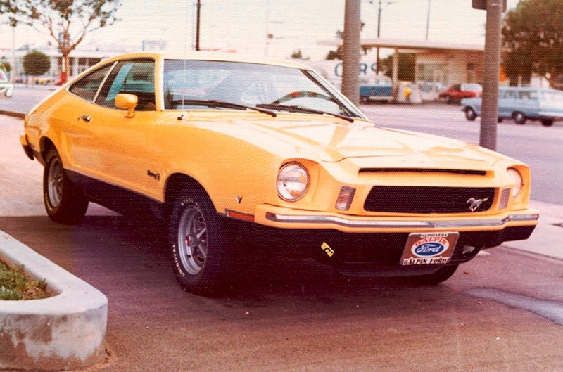 Aged photo of Orange Mustang II at Galpin Ford