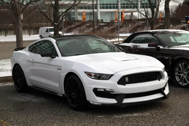 A front end view of a white Ford Mustang at Ford World Headquarters 