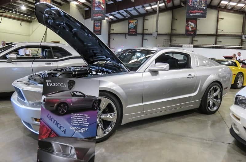 A silver Ford Mustang on display with the hood up