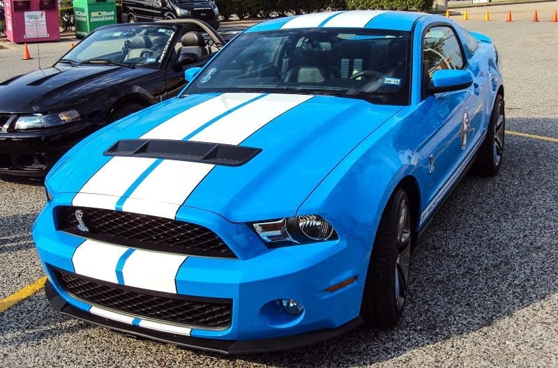 A closeup of a blue and white Ford Mustang on display