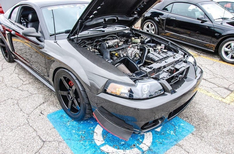 A front view of a grey Ford Mustang with the hood up