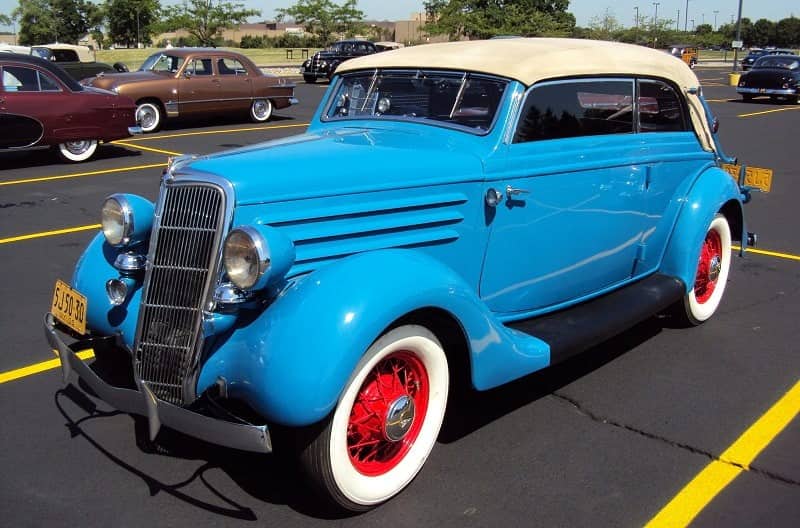 A front side view of a classic blue vehicle on display 