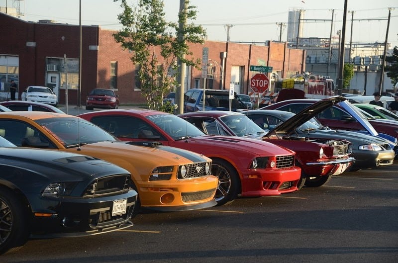A lineup of Ford Mustangs of different color on display 