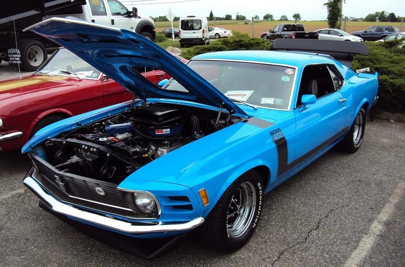 A blue Ford Mustang on display with the hood up 
