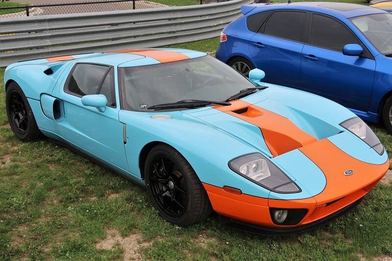 A light blue and orange Ford GT on display with other vehicles 