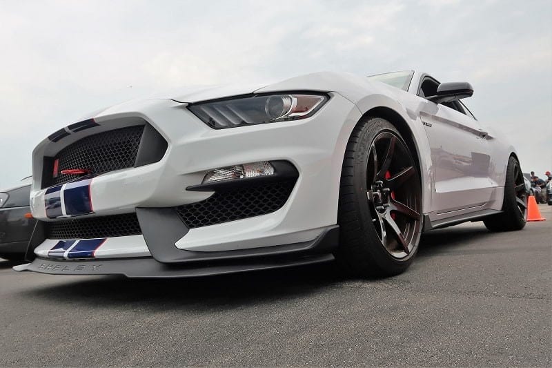 A low front side view of a white Ford Mustang on display 