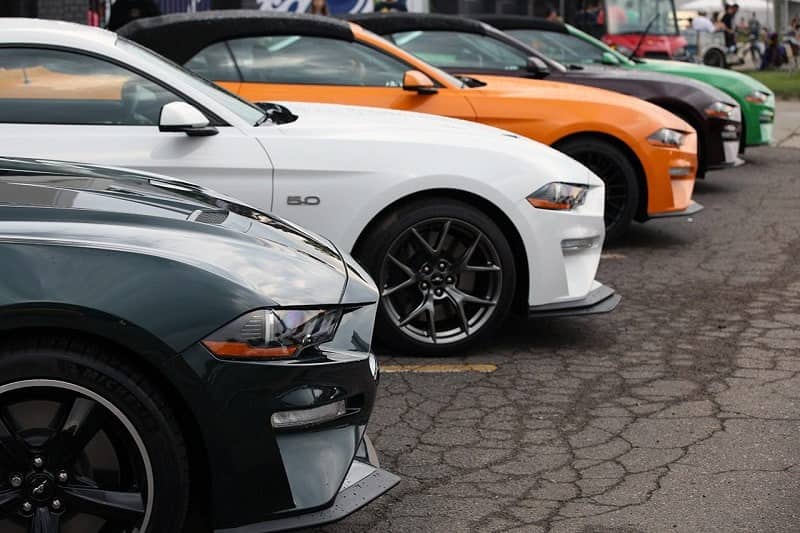 A side view of the front end of several Mustangs on display 
