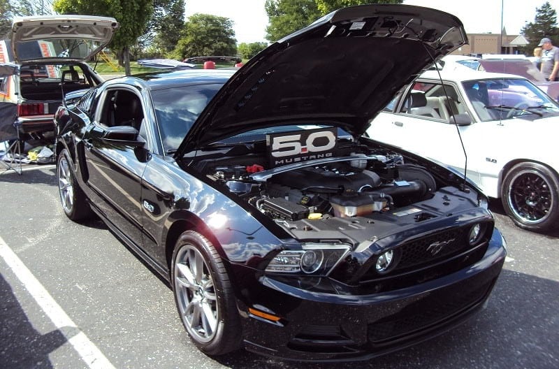 A front side view of a 50th anniversary black Ford Mustang on display 