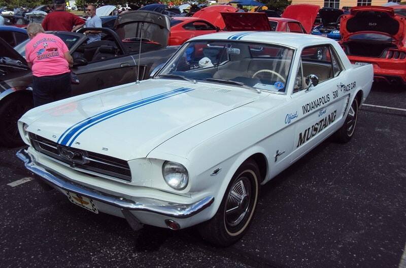 A front side view of a classic white Mustang on display 