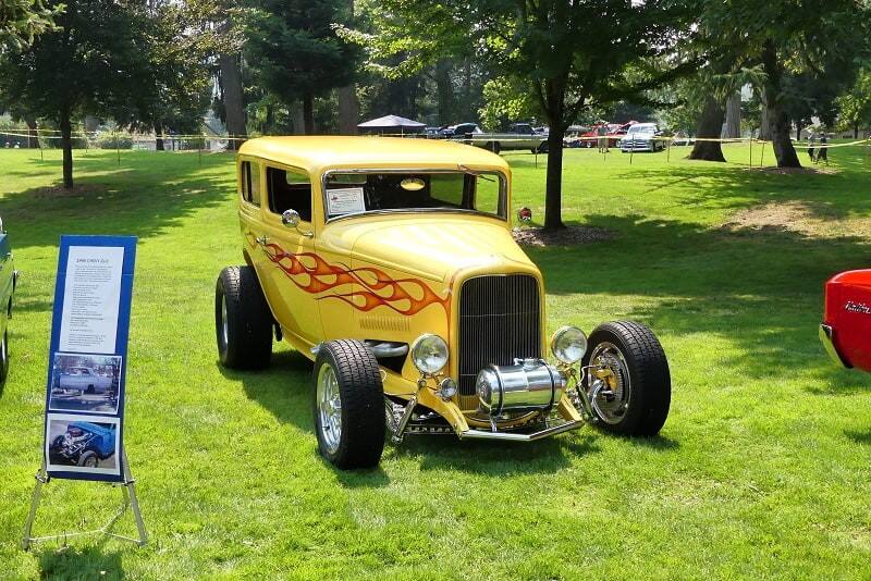 A yellow hot rod on display at the car show 