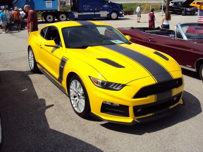 A yellow and black Mustang on display 