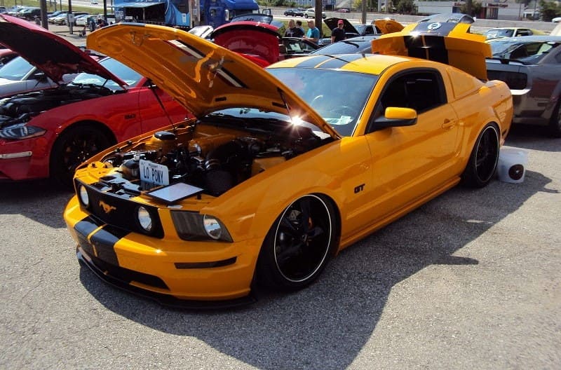 A front side view of a yellow Mustang on display 