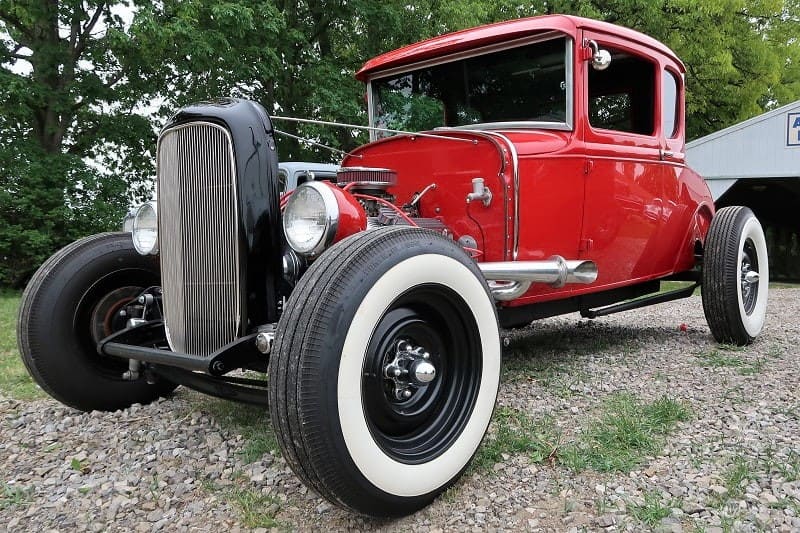 A front side view of a red hot rod on display 