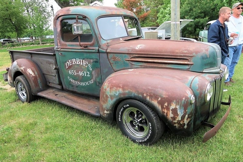 A side view of an old rusty classic truck on display 