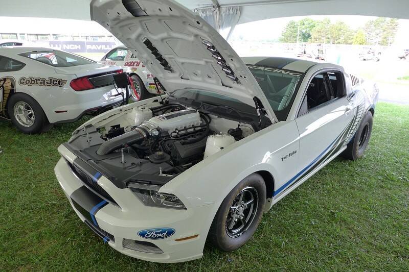 A white Mustang Cobra Jet on display with the hood up 