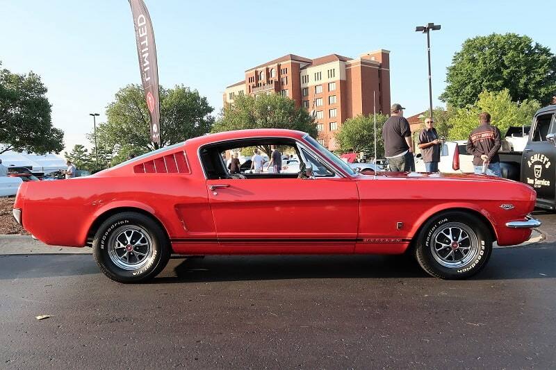 A side view of a classic red Mustang on display 