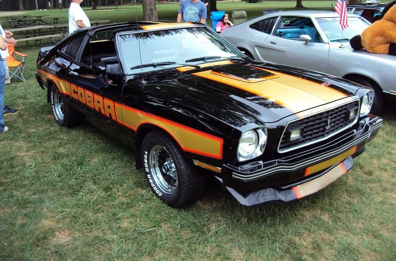 A classic black and orange Ford Mustang Cobra on display 