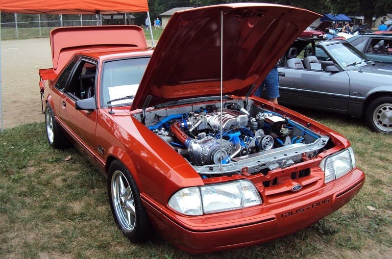 A classic Ford vehicle on display with the hood and trunk open 