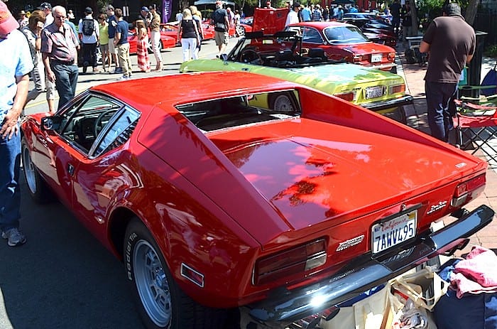 A rear side view of a classic red Pantera on display 