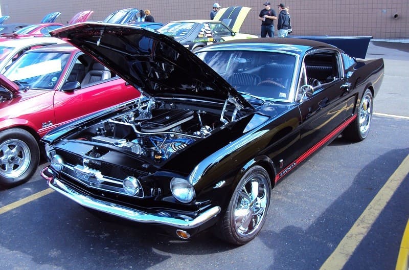 A front side view of a classic black Mustang on display 