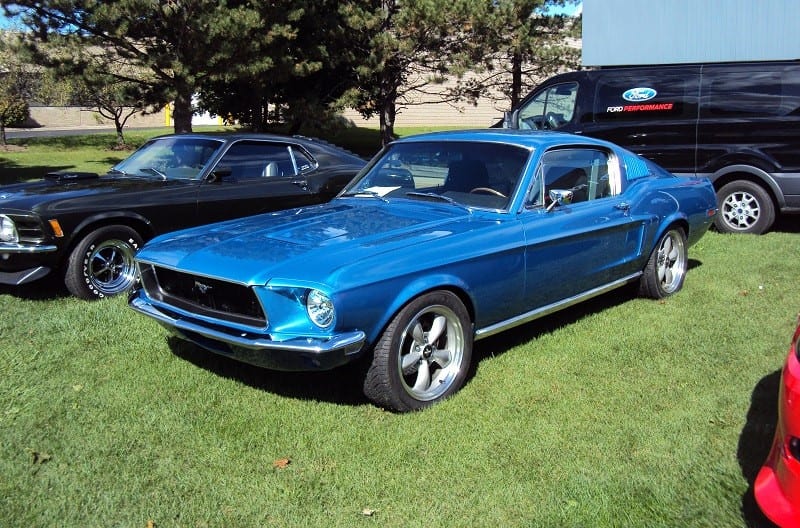A front side view of a classic blue Mustang on display 