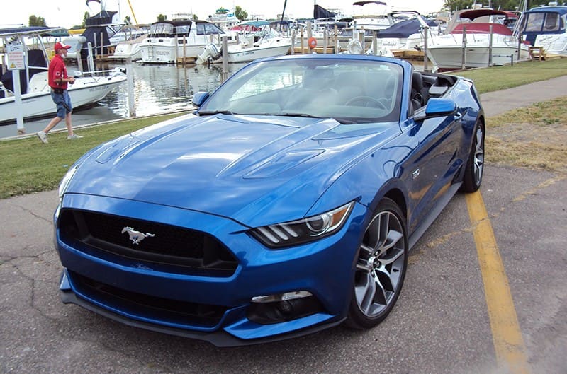 Blue S550 Mustang with boats in background