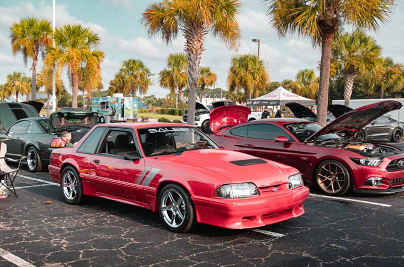 Red Foxbody Mustang with Palm Trees in background