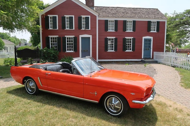 Red Mustang in front of historic house