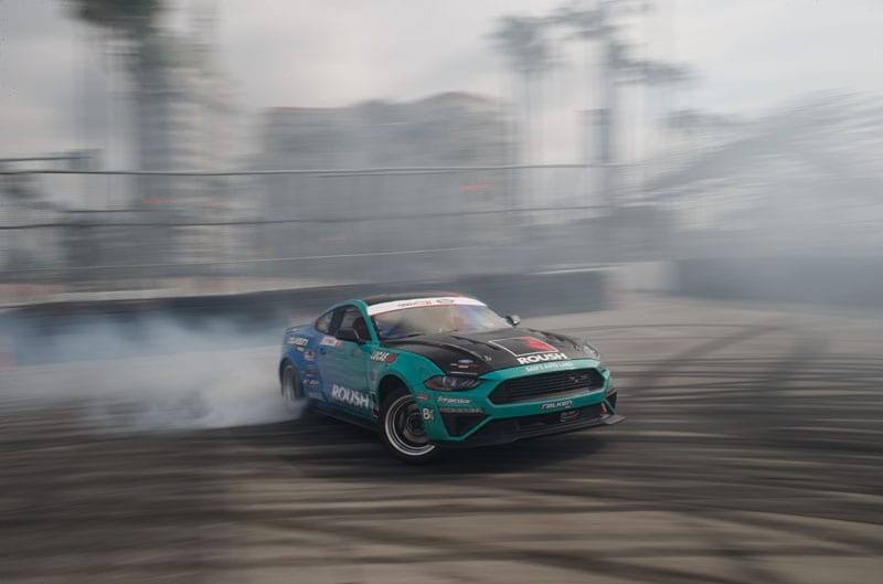 Inside his teal Mustang, Pawlak drifts on Wall Stadium Speedway with a trail of fumes released