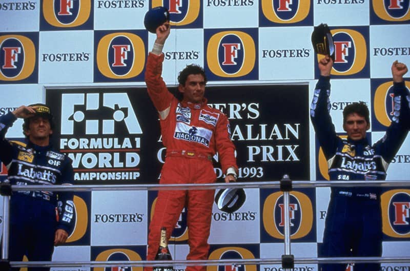 Ayrton Senna on podium in red race suit