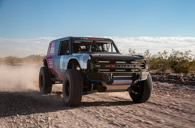 A Ford Bronco R racing through the desert at the SCORE Baja 1000