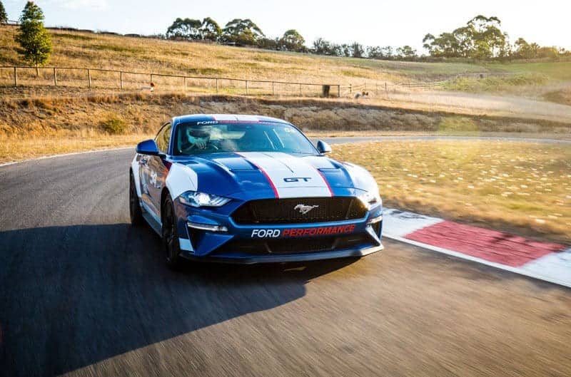 The new blue and white Ford Mustang Supercar racer driving around a corner