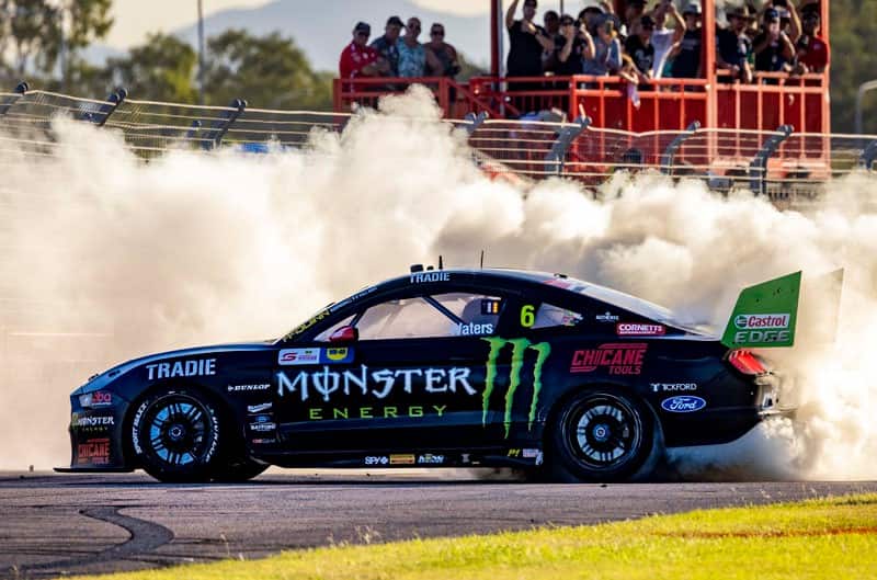 Profile of Monster Energy Mustang on the track doing a burnout