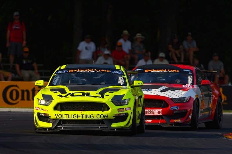 The yellow VOLT Lighting Ford Mustang GT4 racing ahead of the field