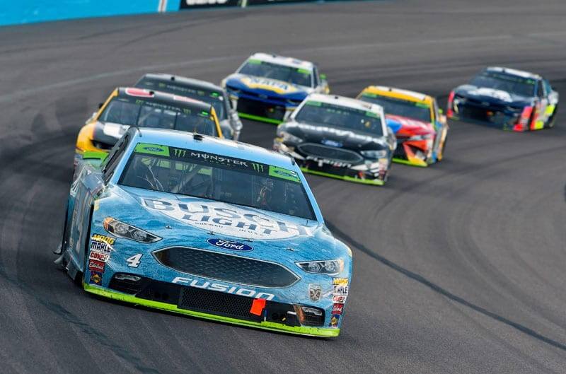 Number 4 Busch Beer Ford Fusion in lead of other vehicles racing down the track