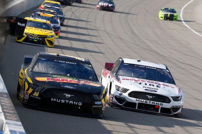 Clint Bowyer and Brand Keselowski Mustangs leading the pack on the track