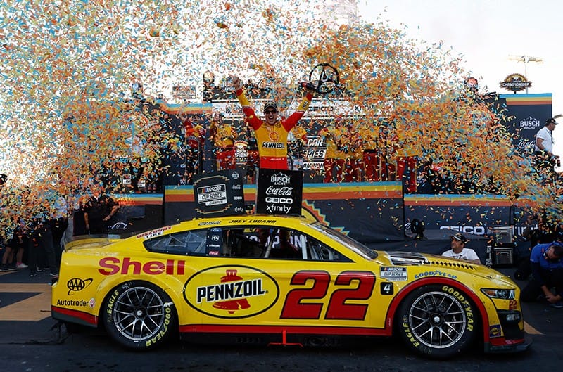 Joey Logano in winners circle with ford mustang