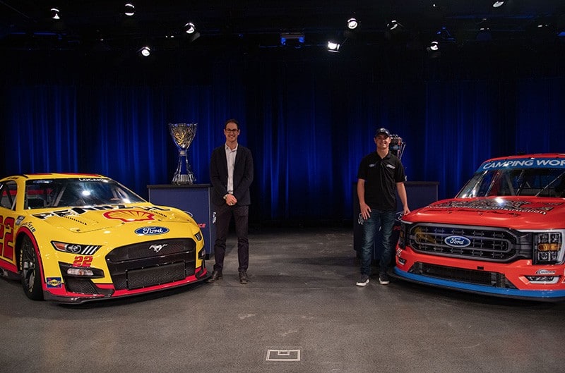 Logano and Smith on stage with winning racecars
